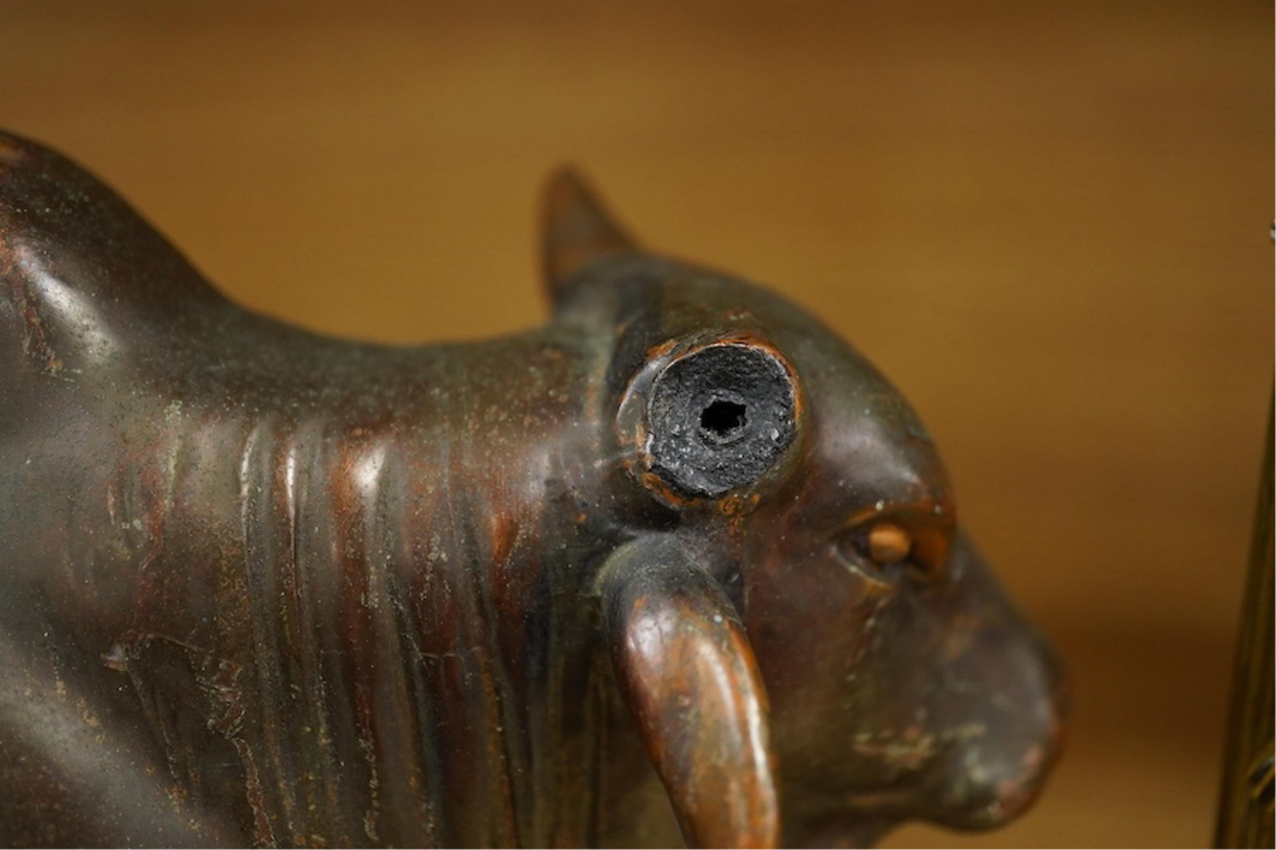 A patinated copper study, 'American Brahman', inscribed EtC, together with a pair of 19th century ormolu candlesticks, largest 30cm high. Condition - fair, bull missing one horn